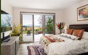 Bedroom featuring access to outside, light wood finished floors, recessed lighting, and a mountain view