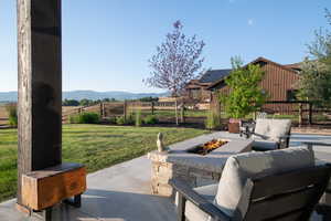View of patio featuring an outdoor fire pit and a rural view