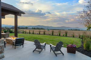 View of patio / terrace with a fire pit, a view of rural / pastoral area, and a mountain view