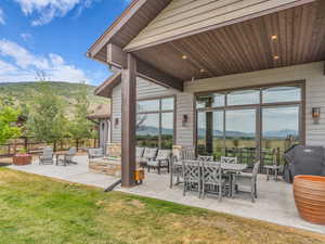 View of patio featuring an outdoor living space with a fire pit, a mountain view, and area for grilling