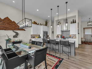Dining area featuring light wood-style floors, recessed lighting, and a chandelier