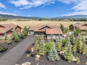 Aerial view of property and surrounding area featuring a mountainous background