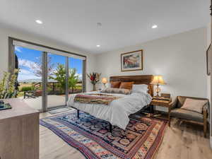 Bedroom featuring access to exterior, light wood-style flooring, and recessed lighting