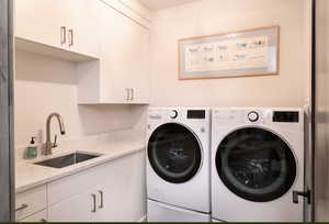 Washroom with cabinet space and washer and clothes dryer