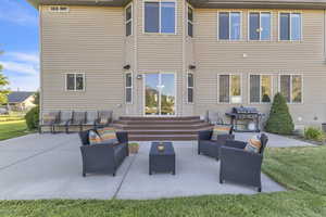Rear view of property featuring an outdoor living space and a patio area