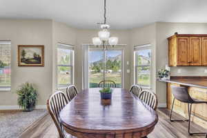 Dining space with light wood-style floors, a chandelier, and plenty of natural light