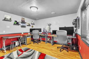 Basement Bedroom with wood finished floors and a textured ceiling