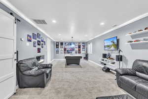 Large Basement family room with light carpet, crown molding, billiards, recessed lighting, and a barn door