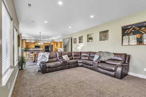 Carpeted living room with recessed lighting and baseboards