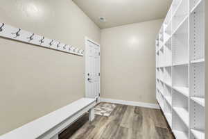 Mudroom featuring wood finished floors and baseboards