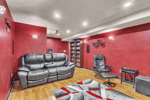 Home theater room with wood finished floors and recessed lighting
