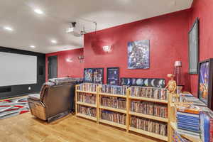 Home theater room with wood finished floors and recessed lighting