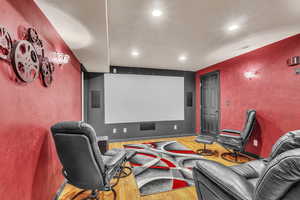 Home theater room with wood finished floors and recessed lighting