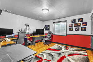 Basement Bedroom with wood finished floors and a textured ceiling