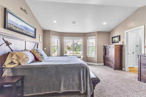 Master bedroom with recessed lighting and vaulted ceiling