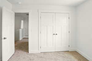Unfurnished bedroom with carpet flooring and a closet