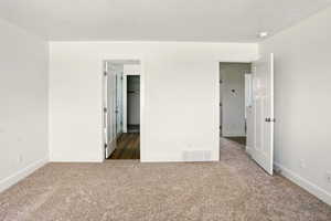 Unfurnished bedroom with carpet and a spacious closet