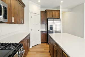 Kitchen with appliances with stainless steel finishes, light wood-type flooring, recessed lighting, and light countertops