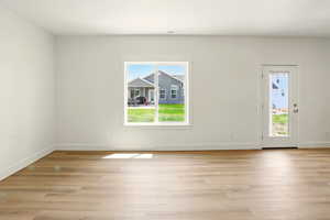 Empty room with plenty of natural light and light wood finished floors