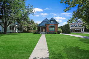 View of front of house with a front lawn and brick siding