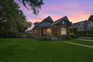 Victorian house with covered porch and brick siding
