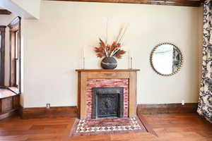 Living room with wood finished floors and a fireplace with flush hearth