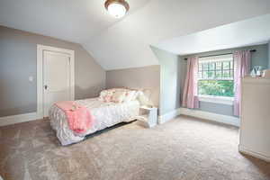 Bedroom with carpet and vaulted ceiling