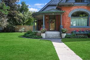Property entrance featuring covered porch and brick siding