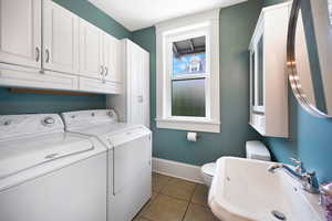 Washroom with washer and dryer and light tile patterned flooring