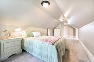 Bedroom with carpet floors and lofted ceiling