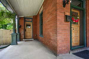 Property entrance featuring brick siding and a porch