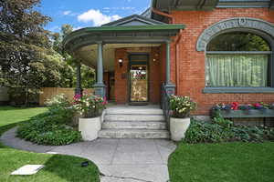 Property entrance featuring brick siding and a porch