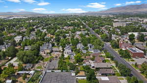 Aerial view of property and surrounding area featuring a mountain backdrop and nearby suburban area