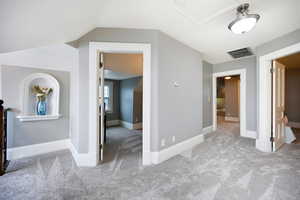 Unfurnished bedroom featuring carpet flooring and vaulted ceiling
