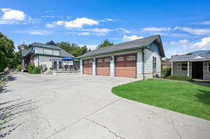View of home's exterior, 3 car garage and storage shed.