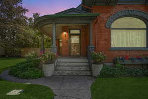 Property entrance featuring brick siding and covered porch