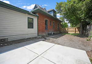 View of property exterior with brick siding and a patio area