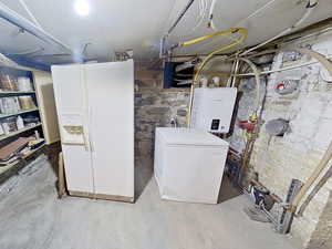 Unfinished basement with white refrigerator with ice dispenser, refrigerator, and tankless water heater