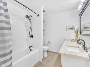 Bathroom featuring vanity, wood finished floors, and shower / tub combo