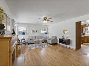 Living room with light wood-style flooring and a ceiling fan