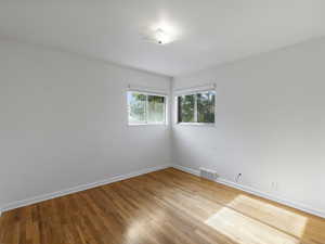 Spare room featuring baseboards and light wood finished floors