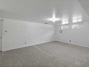 Carpeted empty room with baseboards