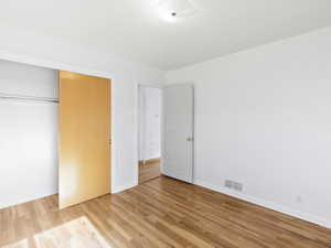 Unfurnished bedroom featuring light wood-style floors and a closet