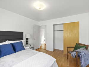 Bedroom with light wood-style floors and a closet