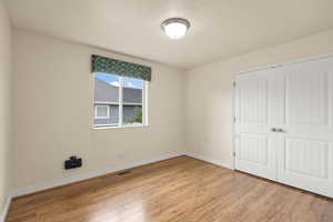 Unfurnished bedroom featuring light wood finished floors and a closet