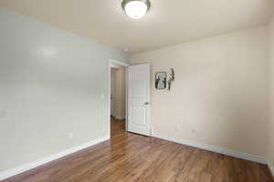 Spare room with baseboards and wood finished floors