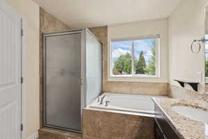 Bathroom with a shower stall, a garden tub, and vanity