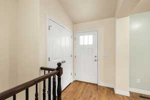 Entrance foyer featuring wood finished floors and vaulted ceiling