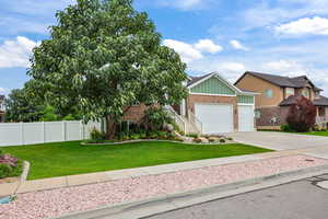 View of front of home featuring board and batten siding, concrete driveway, an attached garage, and brick siding