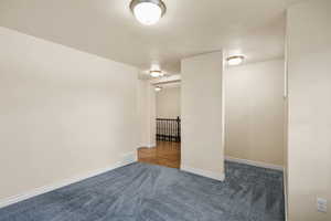 Carpeted empty room with baseboards and a textured ceiling